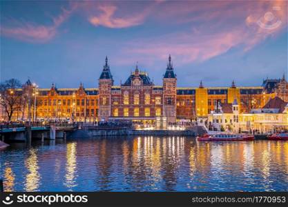 Amsterdam Central Train Station in Netherlands at sunset