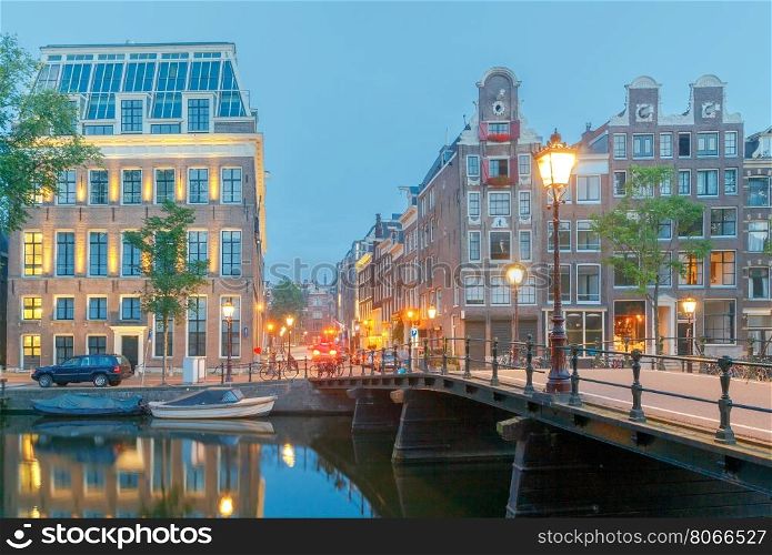 Amsterdam. City Canal at dawn.. City Canal with glowing lights early in the morning. Amsterdam. Netherlands.