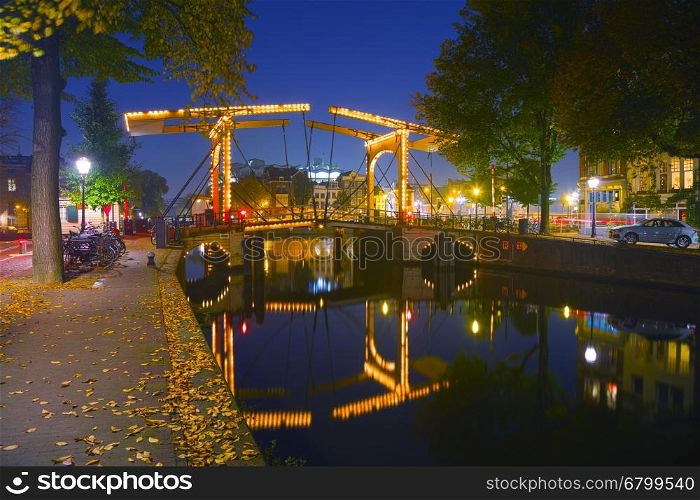 Amsterdam city view with canals and bridges at night