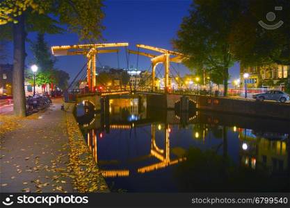 Amsterdam city view with canals and bridges at night