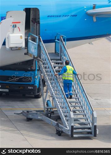 AMSTERDAM, HOLLAND, SEPTEMBER 6: An employee of KLM-Air France is standing at a KLM plane in Amsterdam on 6 september 2013. KLM-Air France is the third biggest airlines in the world. Sept 6, 2013, Amsterdam, Holland