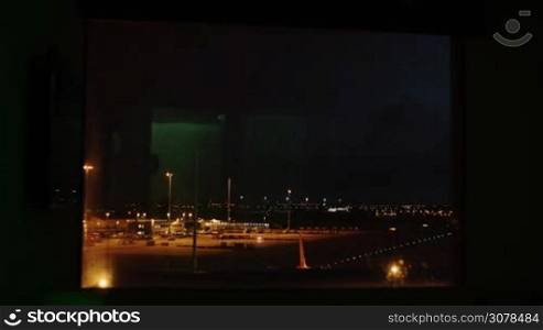 AMSTERDAM, NETHERLANDS - AUGUST 9, 2016: Timelapse view of airport runway from night to day time in Amsterdam Airport Schiphol in the window. It is the fifth busiest airport in Europe