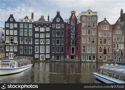 Amsterdam Netherlands city center view .Canal with houses on Damrak street and architecture on the shore