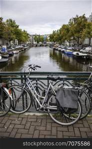 AMSTERDAM,NETHERLANDS - SEPTEMBER 06, 2018: Sunset in Amsterdam.Bicycle parking and traditional old dutch buildings. Netherlands