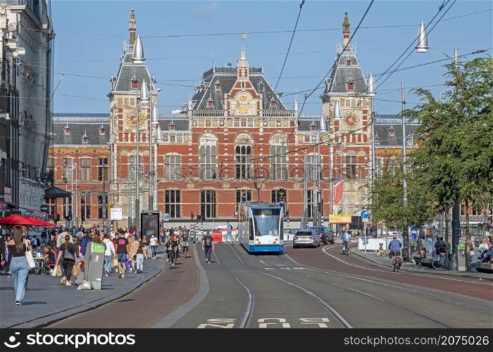AMSTERDAM, NETHERLANDS - September 22, 2021: City scenic from Amsterdam on the Damrak with the Central Station in the Netherlands