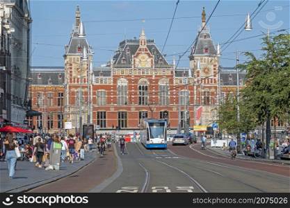 AMSTERDAM, NETHERLANDS - September 22, 2021: City scenic from Amsterdam on the Damrak with the Central Station in the Netherlands