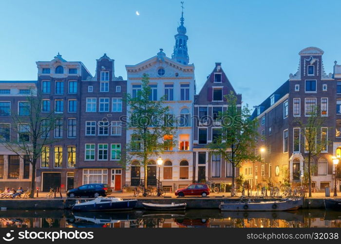 Amsterdam. Night view of the houses along the canal.. Facades of traditional Dutch houses on the canal in the night light. Amsterdam. Netherlands.