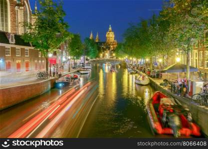 Amsterdam. Night view of the houses along the canal.. Facades of traditional Dutch houses on the canal in the night light. Red light district. Amsterdam. Netherlands.