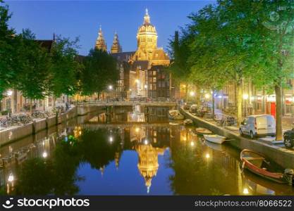 Amsterdam. Night view of the houses along the canal.. Facades of traditional Dutch houses on the canal in the night light. Red light district. Amsterdam. Netherlands.