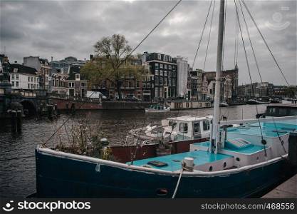 Amsterdams wharf with parked ship on european houses background
