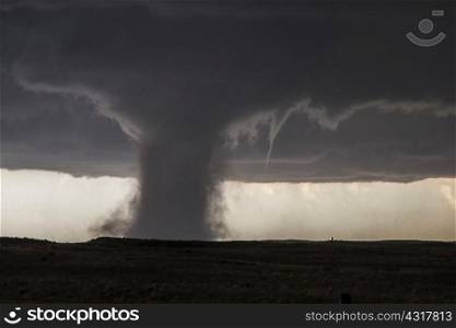 An accessory funnel attempts to touch down while rotating about this very dusty tornado in Colorado