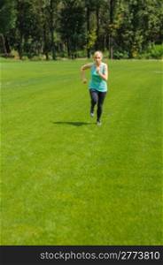 An active beautiful caucasian woman running outdoor in a park