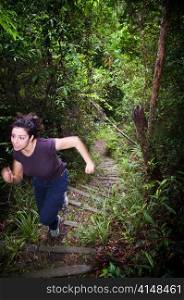 An active young woman hiking in thick jungle