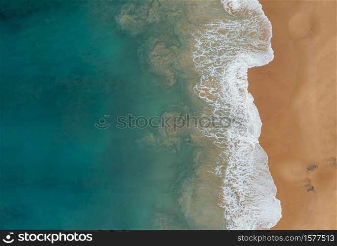 An aerial shot of the beautiful ocean waves meeting the sands on the beach. Aerial shot of the beautiful ocean waves meeting the sands on the beach