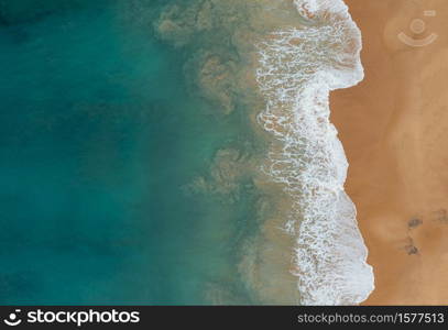 An aerial shot of the beautiful ocean waves meeting the sands on the beach. Aerial shot of the beautiful ocean waves meeting the sands on the beach