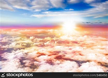 An aerial sunset with clouds below and above