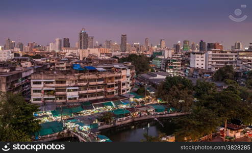 An aerial view of Bangkok city and old market along canal with evening sky