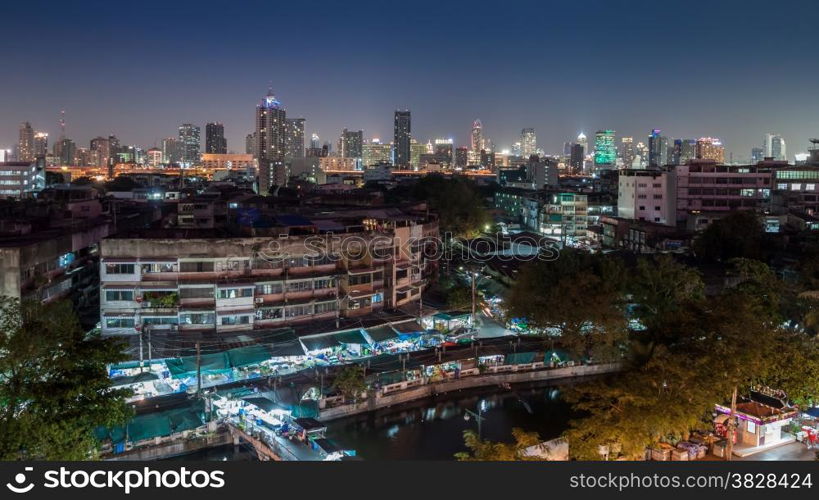 An aerial view of Bangkok city and old market along canal with night sky