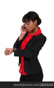 An African American businesswoman looking at her watch.