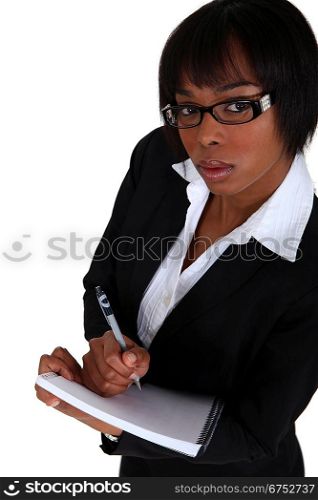 An African American businesswoman taking notes.