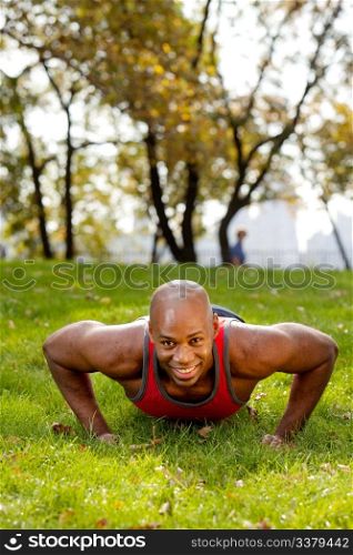 An african american doing push ups in the park