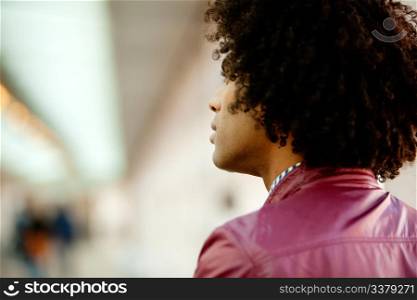 An African American man with afro looking away from the camera