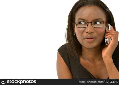 An African American woman using her cell phone with a surprised look on her face, studio shot with copy space
