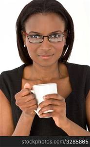 An African American woman warming her hands around a warm drink in a white mug