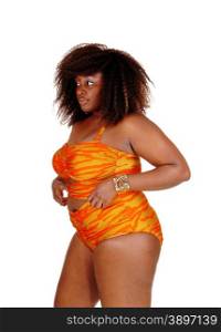 An African American young woman standing in profile in a orange bikini,isolated for white background.