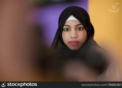 an african muslim woman with a beautiful smile wearing a hijab poses in the studio 