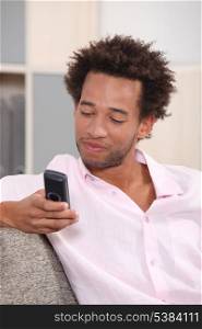 An afro looking at his phone.