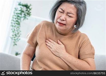 An agonizing elderly woman is experiencing chest pain. Medical attention, senior care service.. An agonizing elderly woman is experiencing chest pain.
