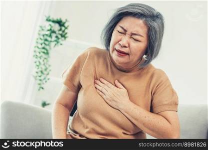 An agonizing elderly woman is experiencing chest pain. Medical attention, senior care service.. An agonizing elderly woman is experiencing chest pain.