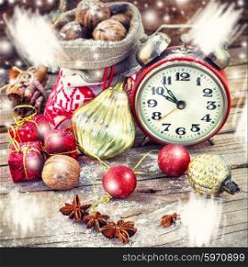 An alarm clock and bag of nuts on the background of Christmas decorations. Christmas card with alarm clock