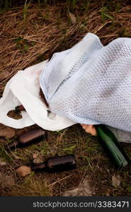 An alcoholic laying in the ditch with liquer bottles