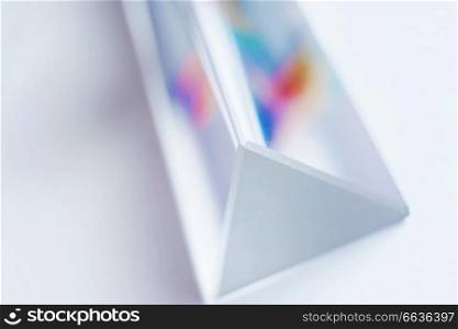 An amazing and beautiful macro with space and clearness about a crystal prism where it can be seen a rainbow on white background