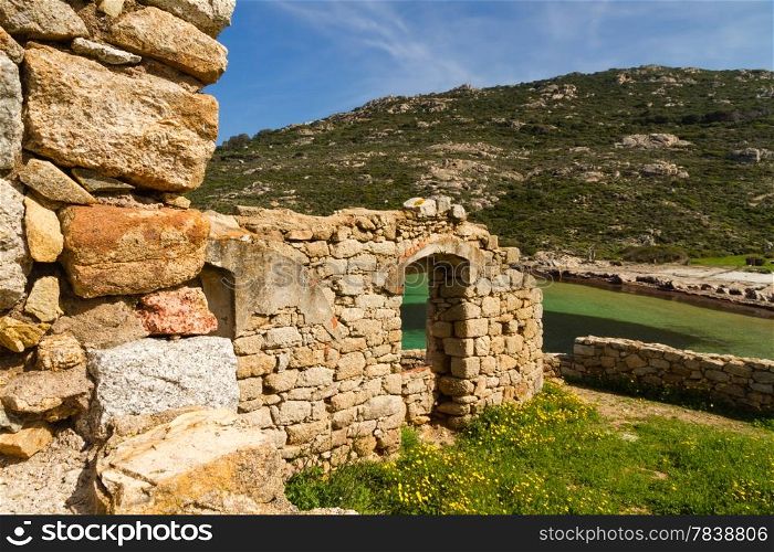 An ancient ruined building overlooking the turquoise mediterranean on the coast of La Revellata near Calvi in Corsica