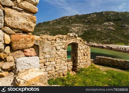 An ancient ruined building overlooking the turquoise mediterranean on the coast of La Revellata near Calvi in Corsica