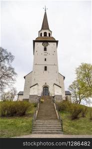An ancient white-stone church with a clock in the town of Mariefred. Sweden