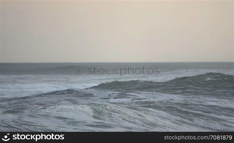 An angry foamy wave crashes near beach