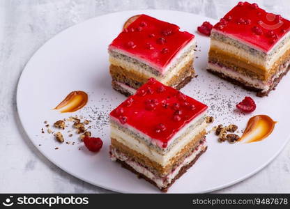 An appetizing dessert with slices of cakes with raspberry and nuts. Appetizing dessert with slices of cakes with raspberry and nuts