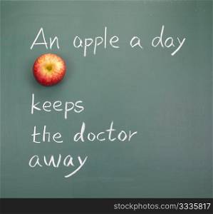 An apple a day keeps the doctor away, words on blackboard.