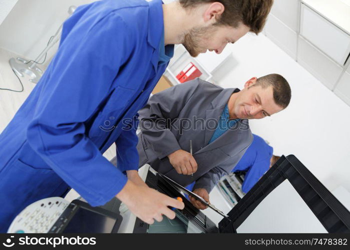 an apprentice fixing a printer