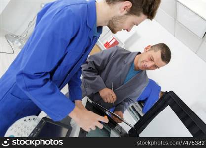 an apprentice fixing a printer