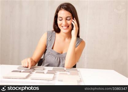 An architect / designer talking on the phone choosing a stone tile