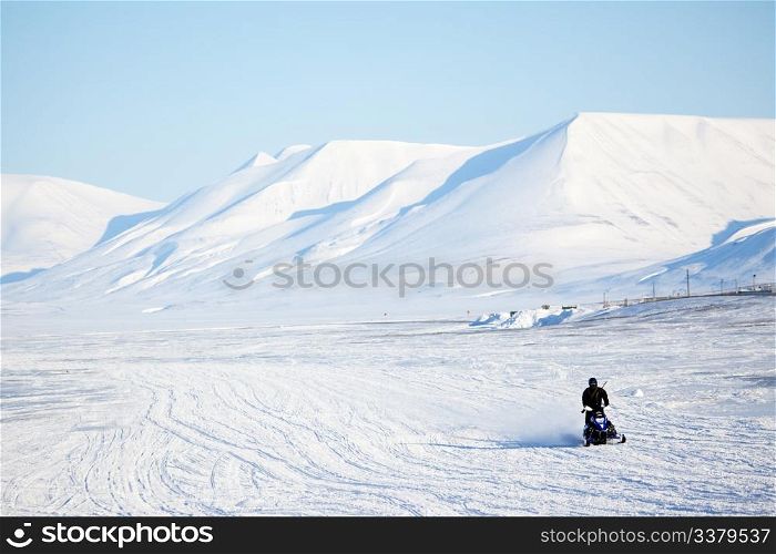 An arctic landscape with a snowmobile in the foreground