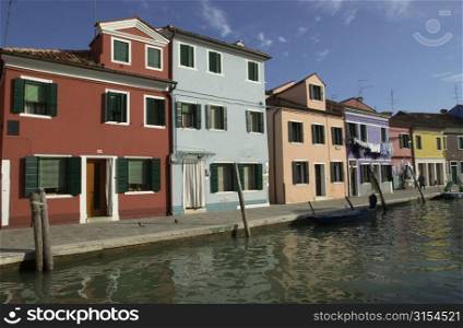 An array of colorful residential buildings along a canal in Venice, Burano, Italy