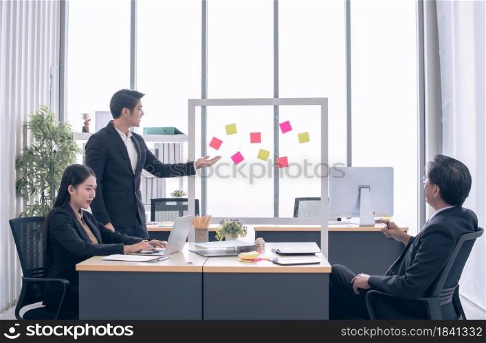 An asian business man is presenting yearly plan to his boss and colleague in meeting room
