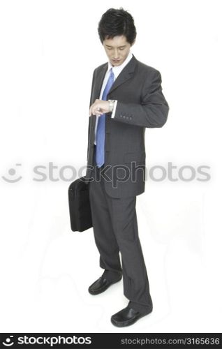 An asian businessman checks his watch