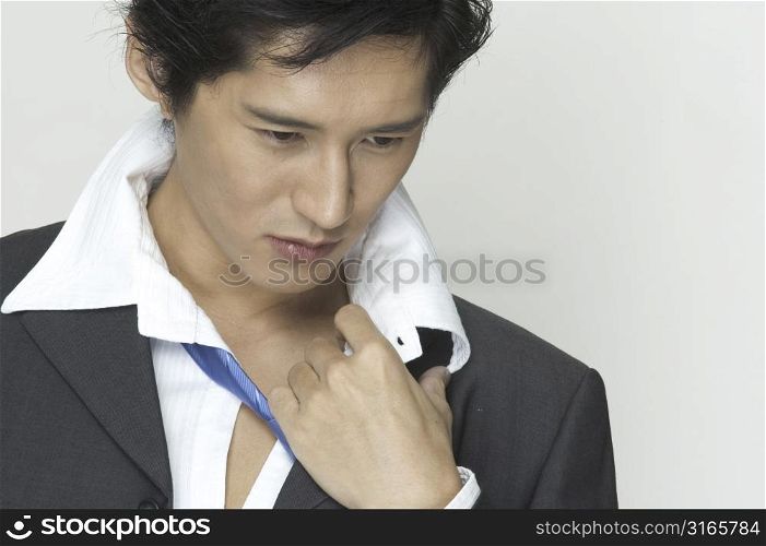An asian businessman gets ready to relax after work